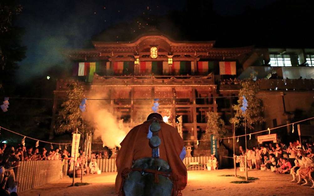 夜の本堂前で火渡りへ向かう山伏